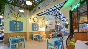 Un restaurante con mobiliario azul y un letrero verde que anuncia comida.