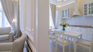 A modern kitchen with white cabinetry, a dining table, and chairs.