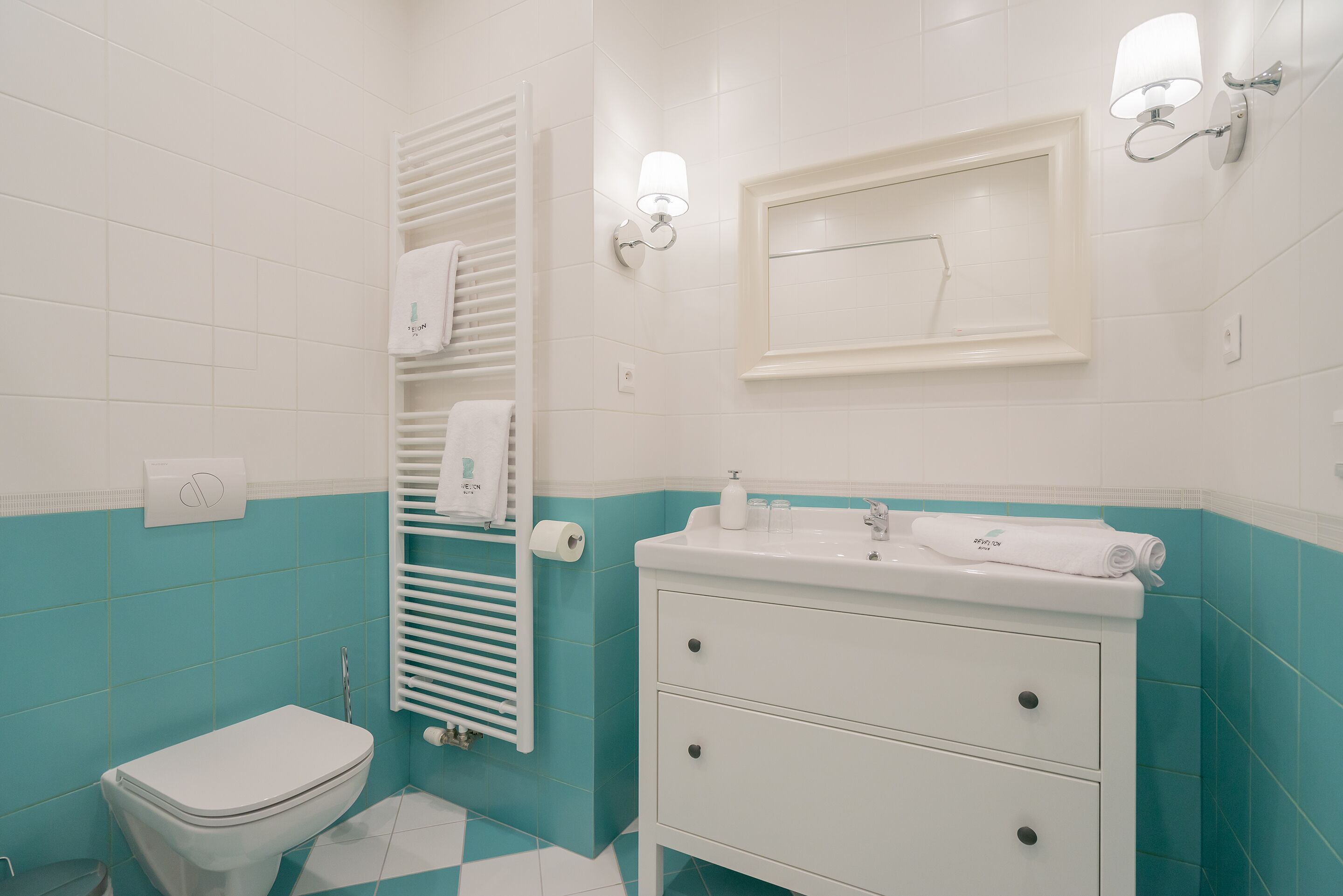 Un baño con inodoro, lavabo y toallero.