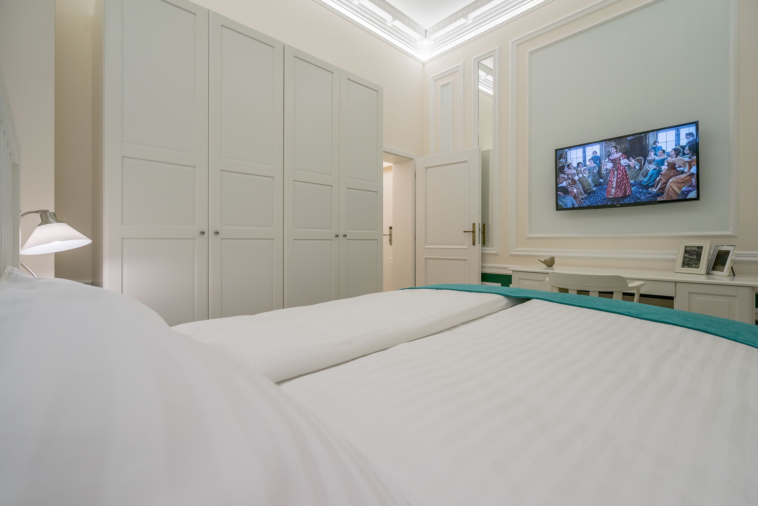 A hotel room with two beds, a television, a desk, and a wardrobe.