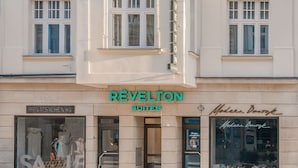 A building with a classic architectural style, featuring a central entrance with a sign reading "Réveltion Suites."