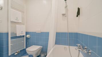 Ein Badezimmer mit Badewanne, Toilette und Handtuchhalter.