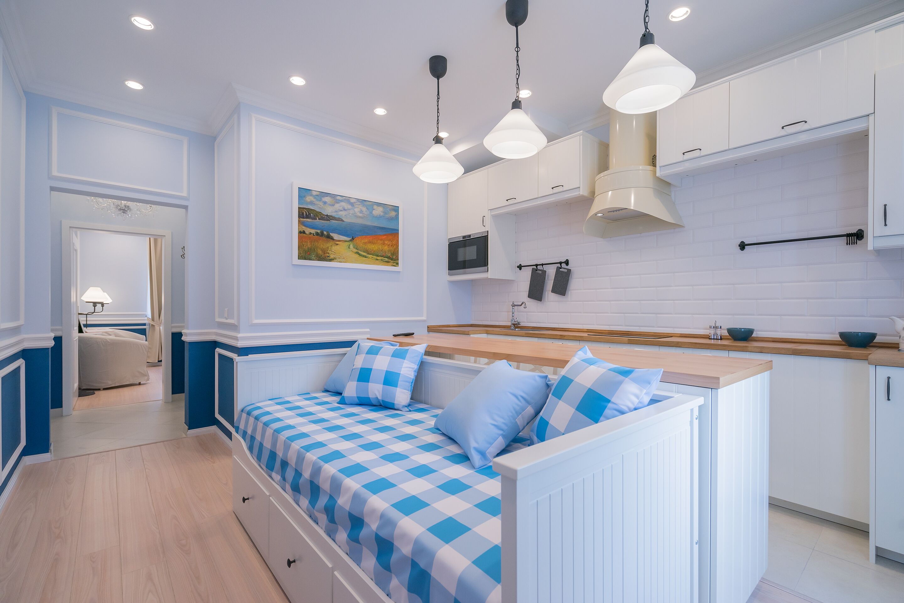 A modern kitchen with white cabinets, a built-in oven, and a microwave.
