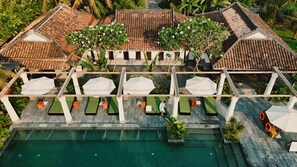 An aerial view of a resort with a swimming pool, outdoor seating, and traditional tiled roofs. - Grand Signature Resort Hoi An by M Village, a brand of Modern Village Lifestyle (Da Nang)