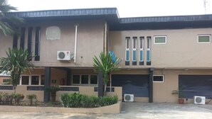 A building with a flat roof, multiple windows, and air conditioning units. - Divine Fountain Agidingbi (Lagos)
