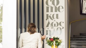 Une personne est en train de peindre un mur avec les mots « bienvenue » écrits en grandes lettres.