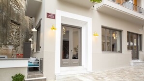 Un bâtiment doté d’une façade en pierre, d’une entrée blanche et d’une enseigne indiquant son nom.