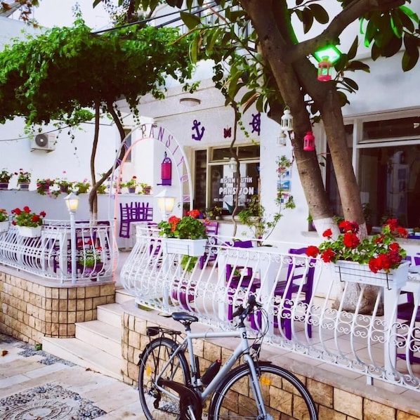 Un edificio blanco con un letrero que dice "PANSIT" y una bicicleta estacionada en la parte delantera.