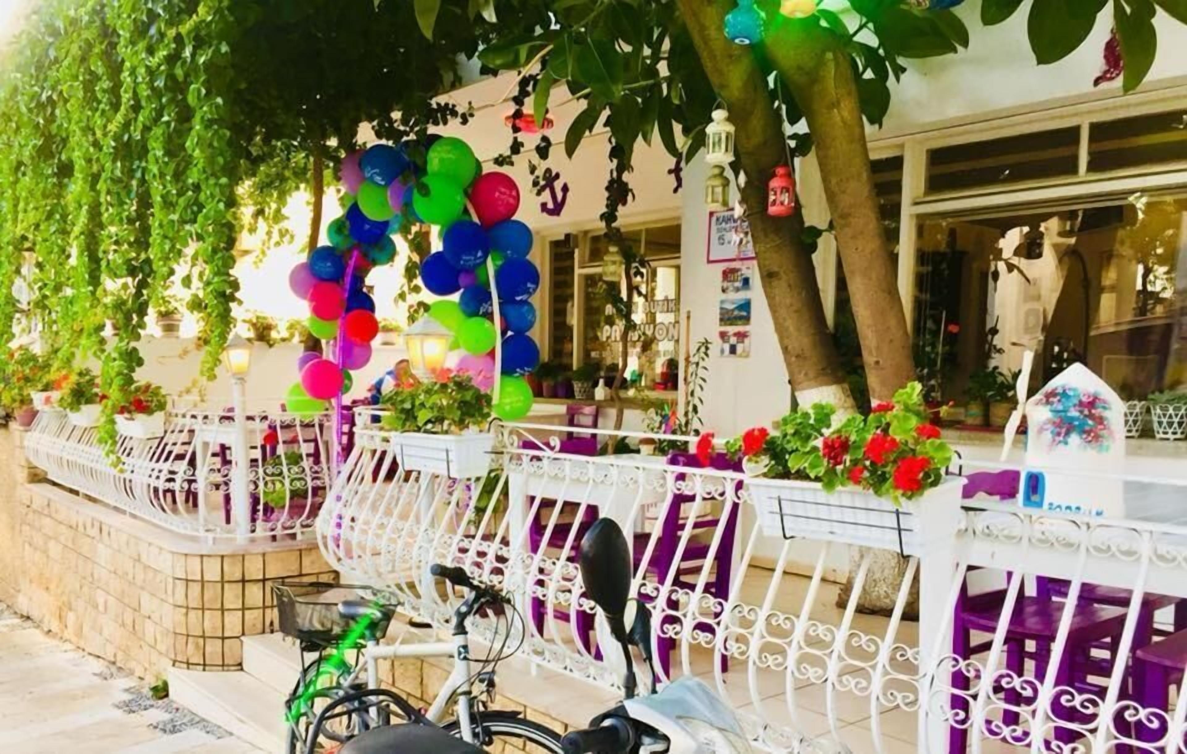 A white metal fence with purple chairs and a bicycle parked in front.
