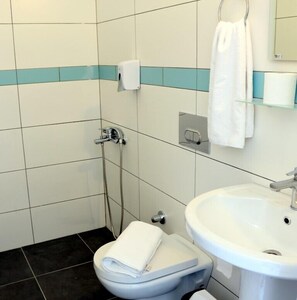 Un baño con inodoro, lavamanos y ducha.