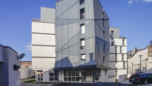 A modern building with a geometric facade, large windows, and a parking area. - Appart'hôtel Odalys City - Orléans Centre (Orléans)