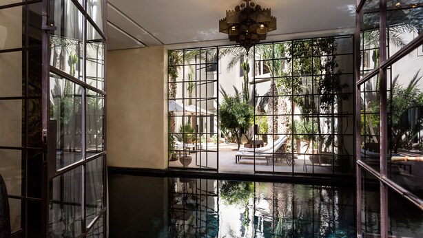 A room with a large window, a pool, and a ceiling light. - Palais Khum (Marrakech)