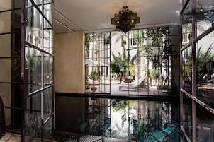 A room with a large window, a pool, and a ceiling light.