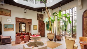 A spacious interior with a central fountain, seating areas, and large windows providing natural light. - Palais Khum (Marrakech)