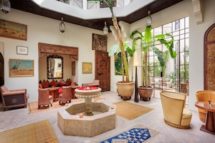 A spacious interior with a central fountain, seating areas, and large windows providing natural light.