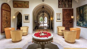 A lobby with a fountain, arched doorways, and traditional decor. - Palais Khum (Marrakech)