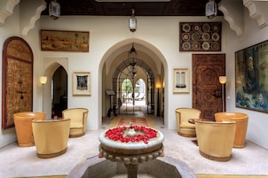 A lobby with a fountain, arched doorways, and traditional decor.