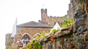A historic stone building with a tower and arched windows.