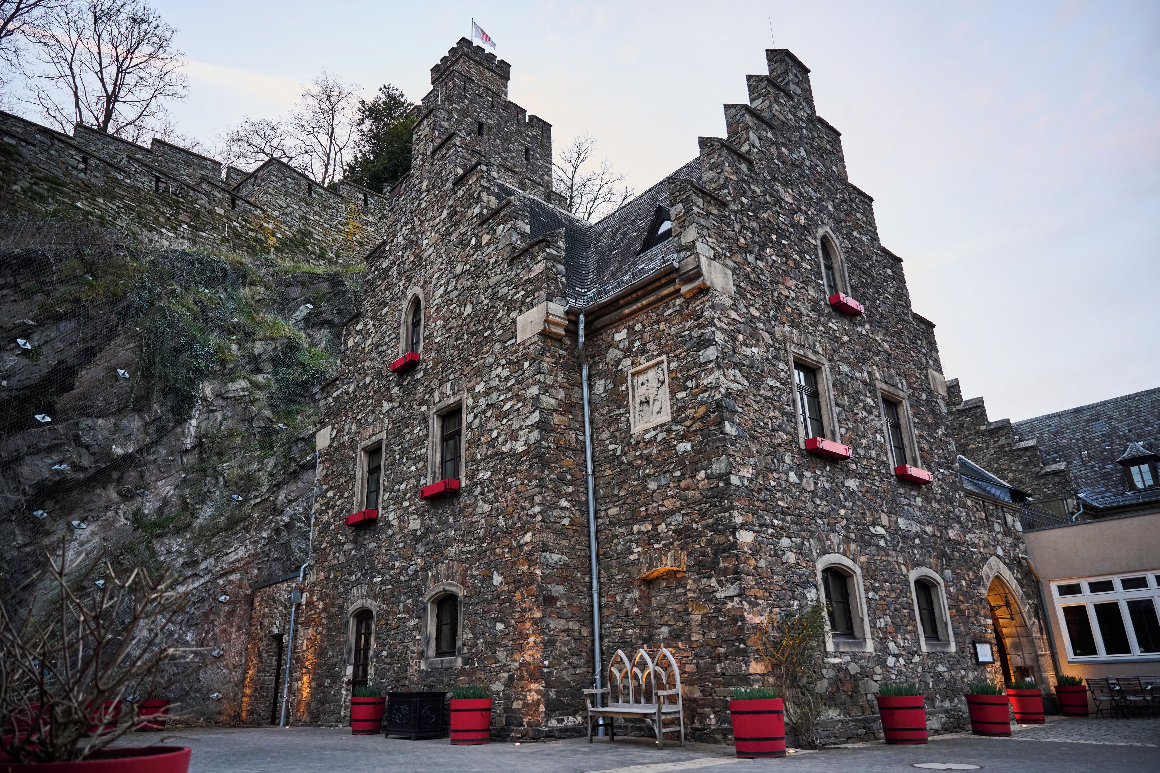 A historic stone building with multiple windows and a flag.