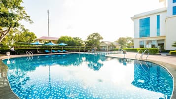 Una piscina al aire libre, tumbonas
