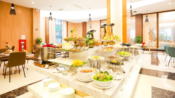 A buffet with various dishes and a seating area with chairs and tables. - Muong Thanh Luxury Nhat Le Hotel (Dong Hoi)