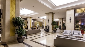 A spacious lobby with a high ceiling, marble flooring, and modern furnishings including sofas and chairs. - Muong Thanh Luxury Nhat Le Hotel (Dong Hoi)