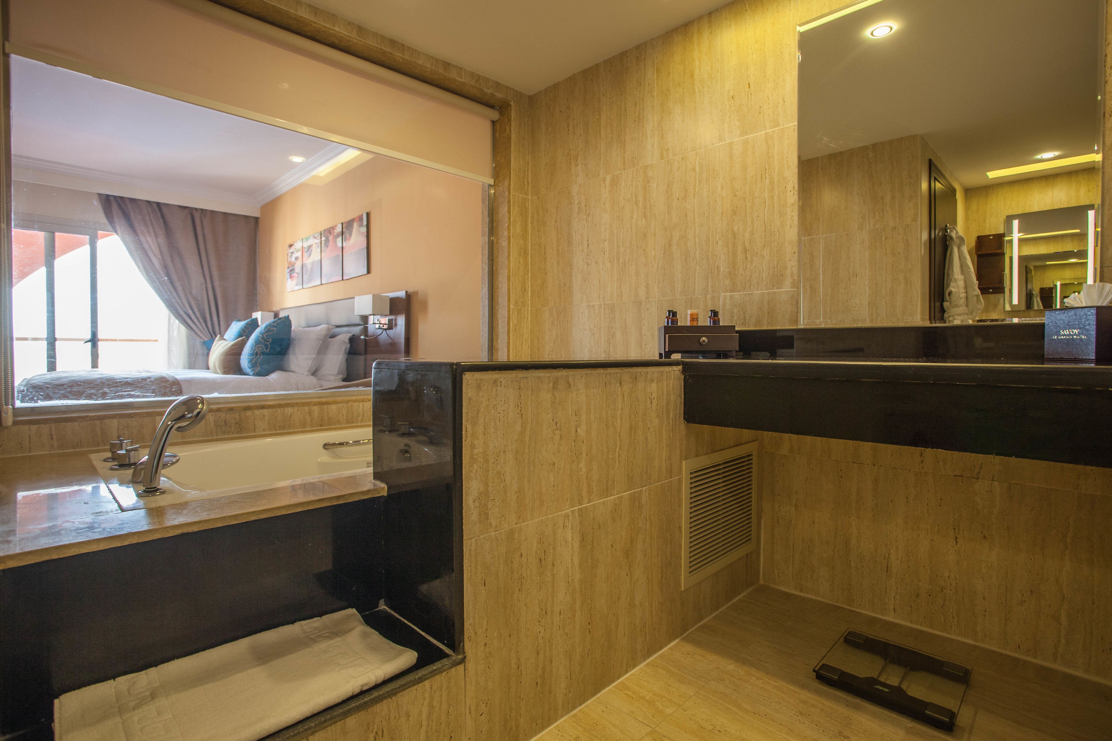 A modern bathroom with a large mirror, a bathtub, and a vanity with a sink.