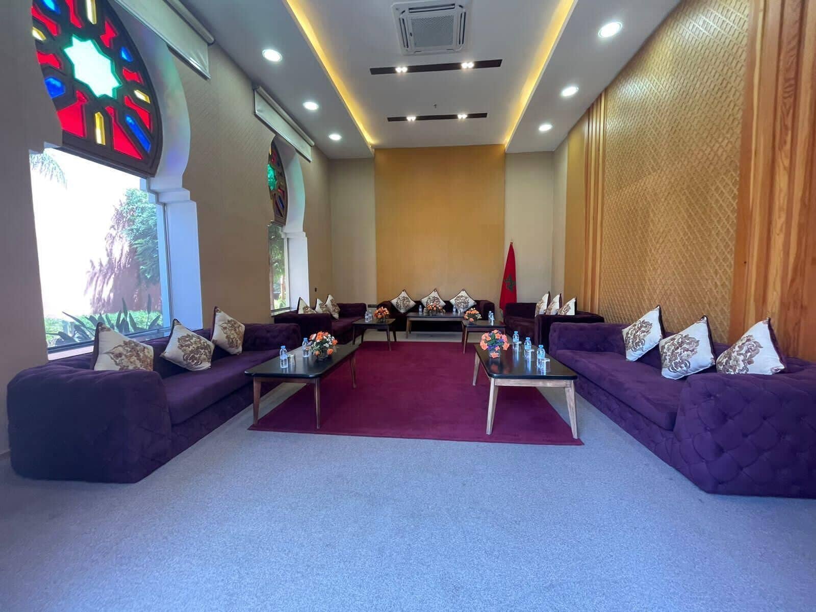 Una sala de conferencias con dos sofás, una mesa central y una bandera.