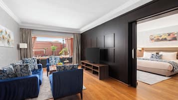 Een moderne woonkamer met een zithoek, een televisie en een bed.