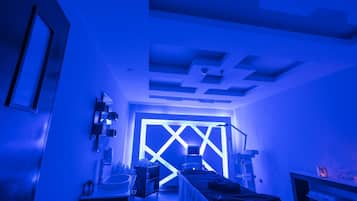 Una habitación con un diseño moderno en el techo, una cama, un escritorio y una computadora.