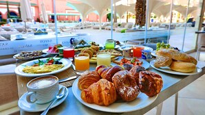Un bufé de desayuno con cruasanes, pastelería y diversas bebidas.