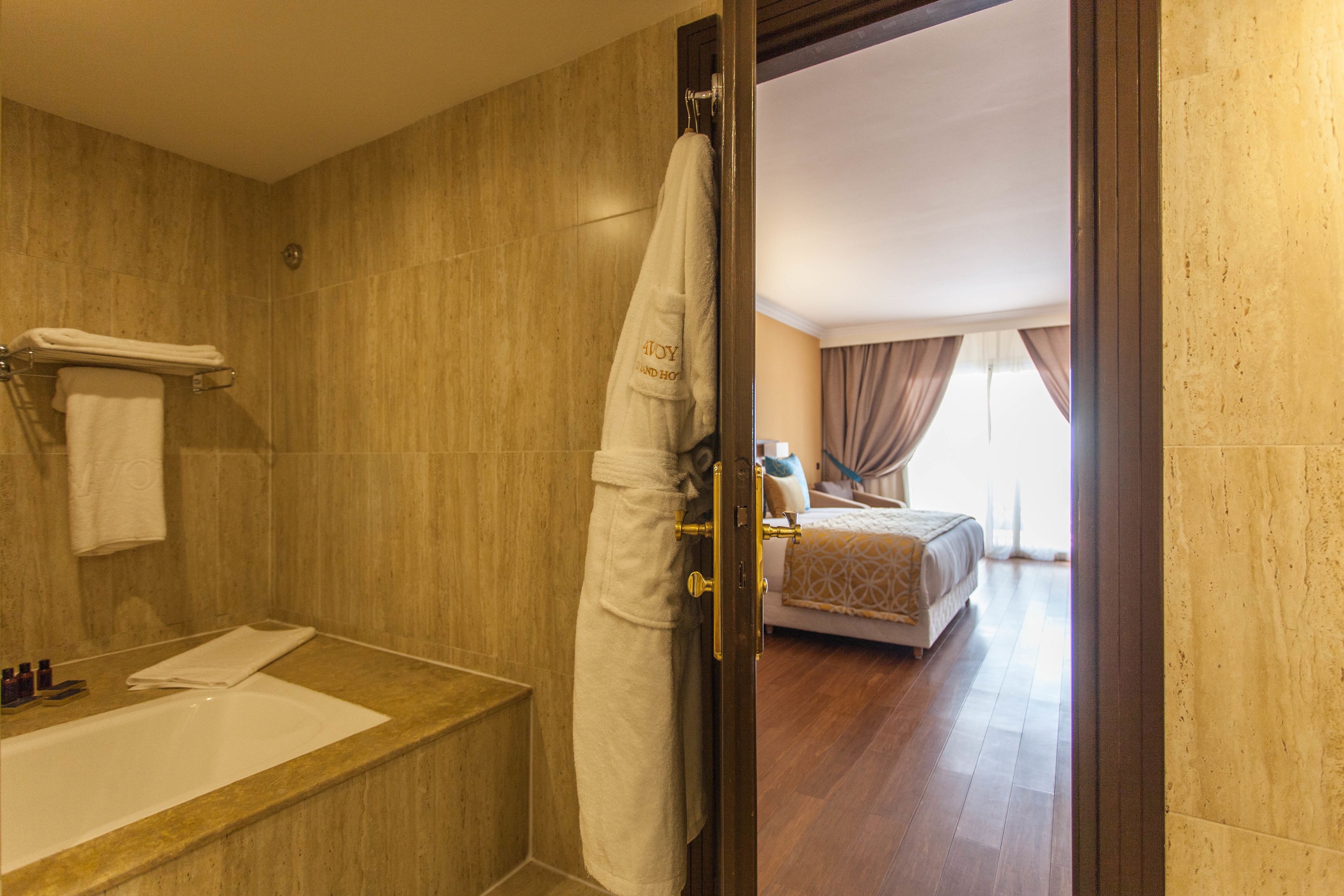 A bathroom with a bathtub, a towel rack, and a shower curtain.