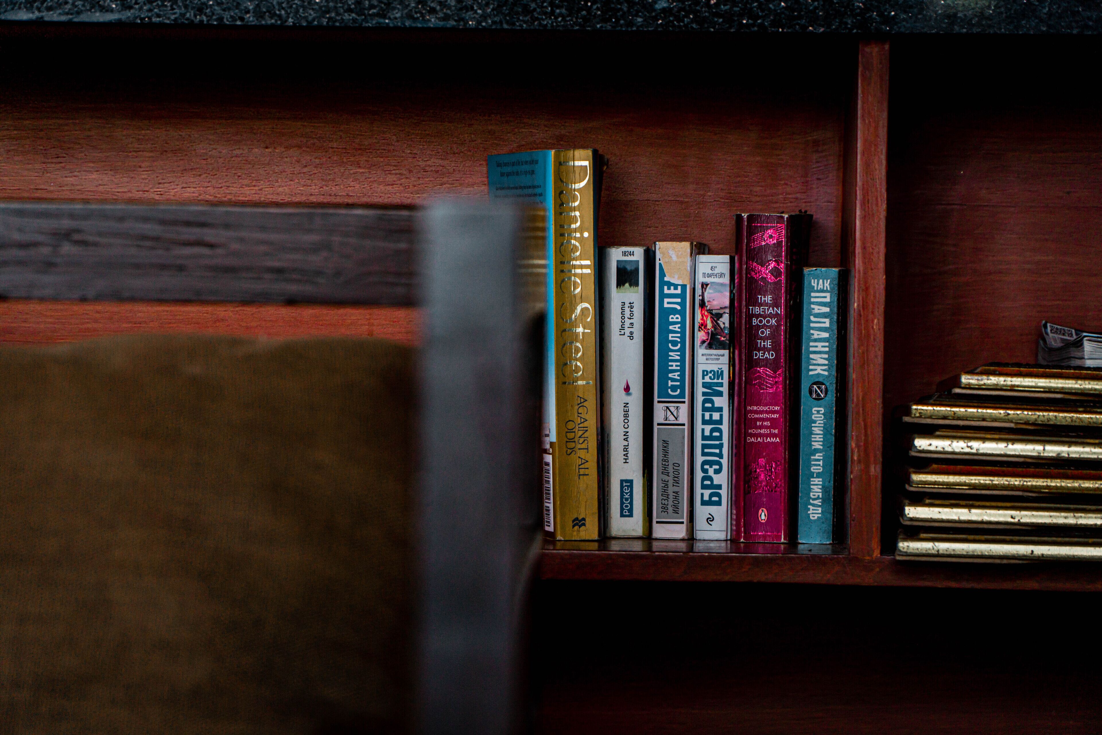 A bookshelf with various books, including titles like "Against All Odds" and "The Tibetan Book of the Dead".
