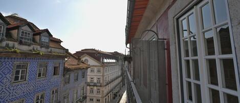 Una calle estrecha flanqueada por edificios, con balcones y una mezcla de estilos arquitectónicos.