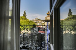 A view from a window with ornate iron railings, overlooking a green landscape and buildings with traditional architecture. - My Ribeira Guest House (Porto)
