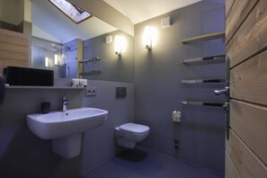 Un baño moderno con un lavamanos grande, inodoro y ducha.