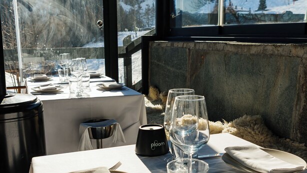A dining table set for two with a view of snow-covered mountains through large windows. - Super G (Courmayeur)
