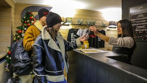 A reception area with a wooden interior, a Christmas tree, and a counter with a menu. - Super G (Courmayeur)
