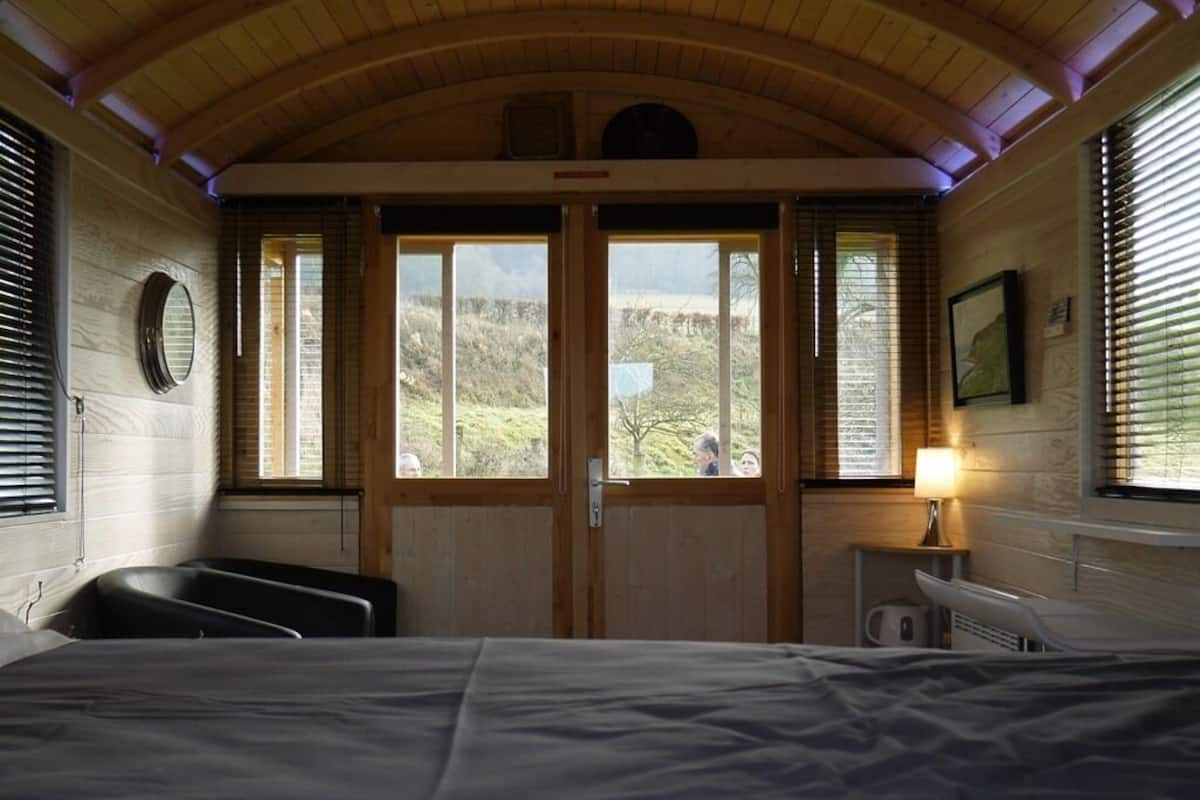 Una habitación con cama, escritorio y ventana con vistas al exterior.