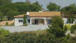 Een modern huis met een pannendak, een schotelantenne en een overdekte veranda.