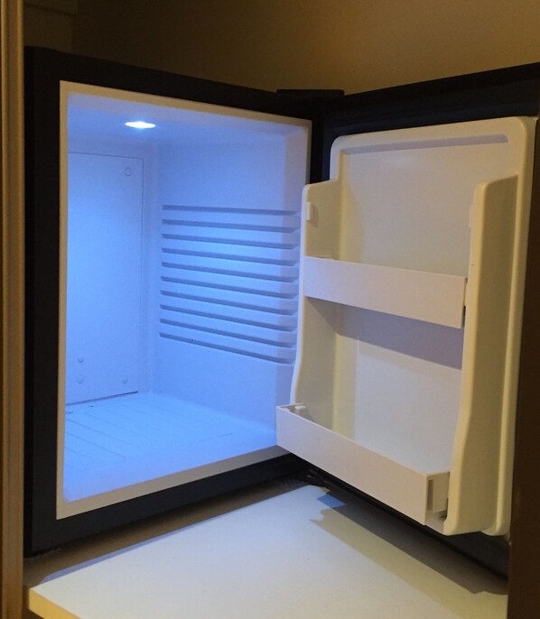An open refrigerator with shelves and a freezer compartment. - Les Balcons de Maragon (Carcassonne)