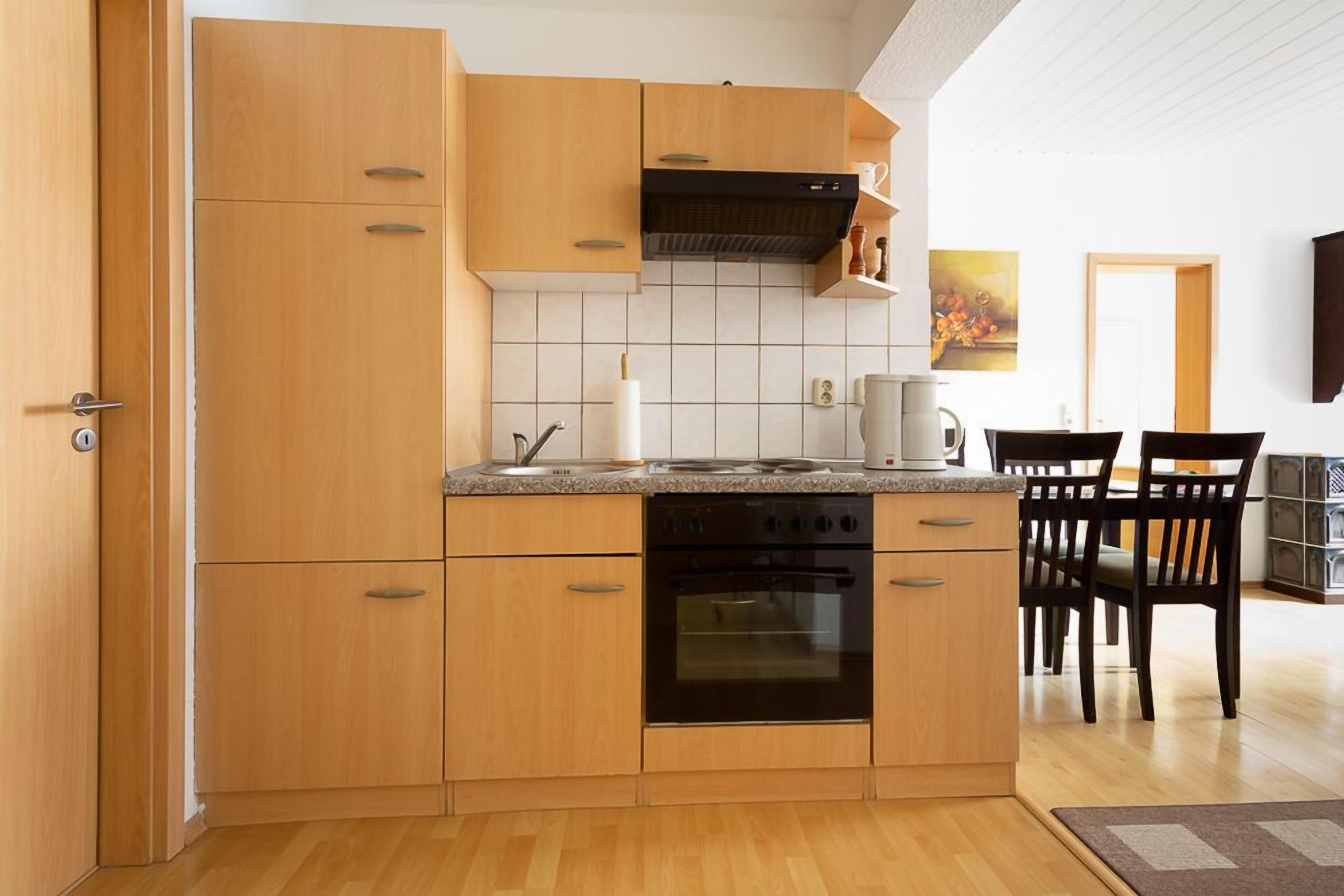 Una cocina moderna con armarios de madera, horno empotrado y encimera de granito.