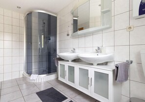 Familie appartement | Badkamer | Een douche, zeep, shampoo, toiletpapier