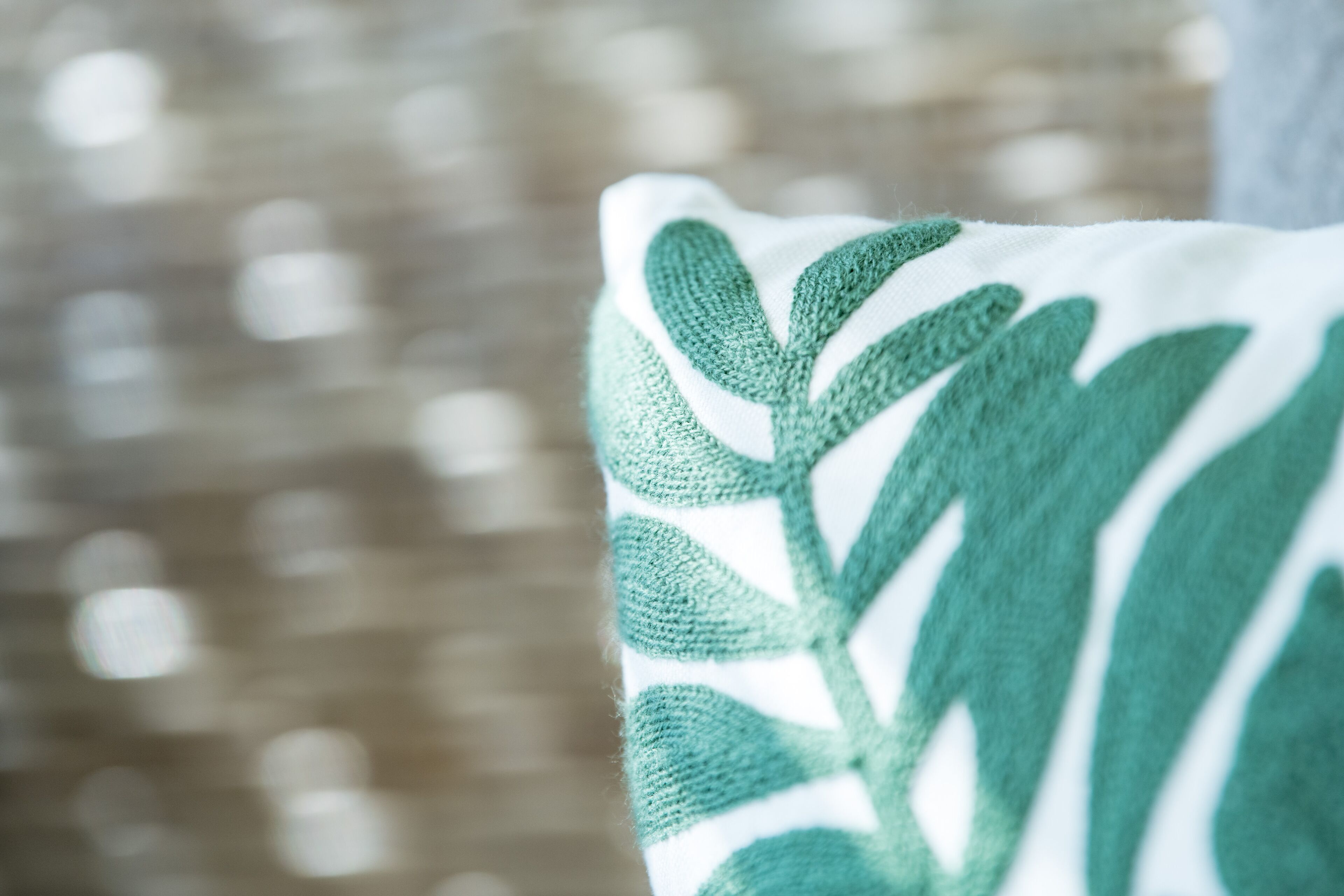 A close-up of a pillow with a green leaf pattern.