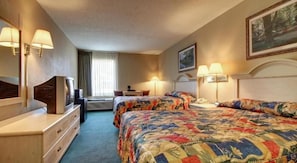 A hotel room with two beds, a desk, a television, and a window with curtains. - Key West Inn - Baxley (Baxley)