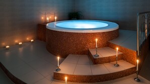 Un espace spa moderne avec un jacuzzi, des bougies et un escalier.
