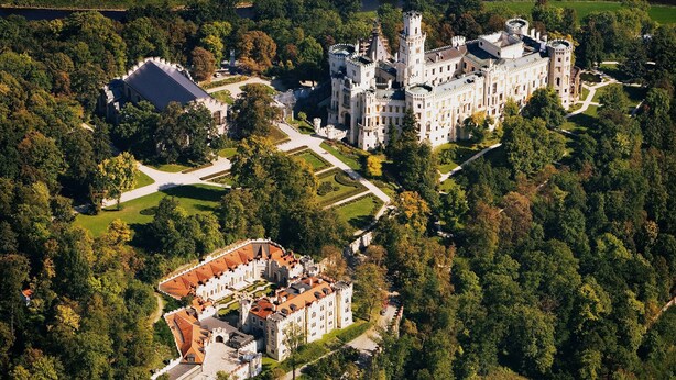 Un vaste château historique doté de nombreuses tours et d’un jardin bien entretenu.