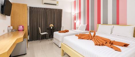 A hotel room with two beds, a desk, a chair, a TV, and a window with curtains.
