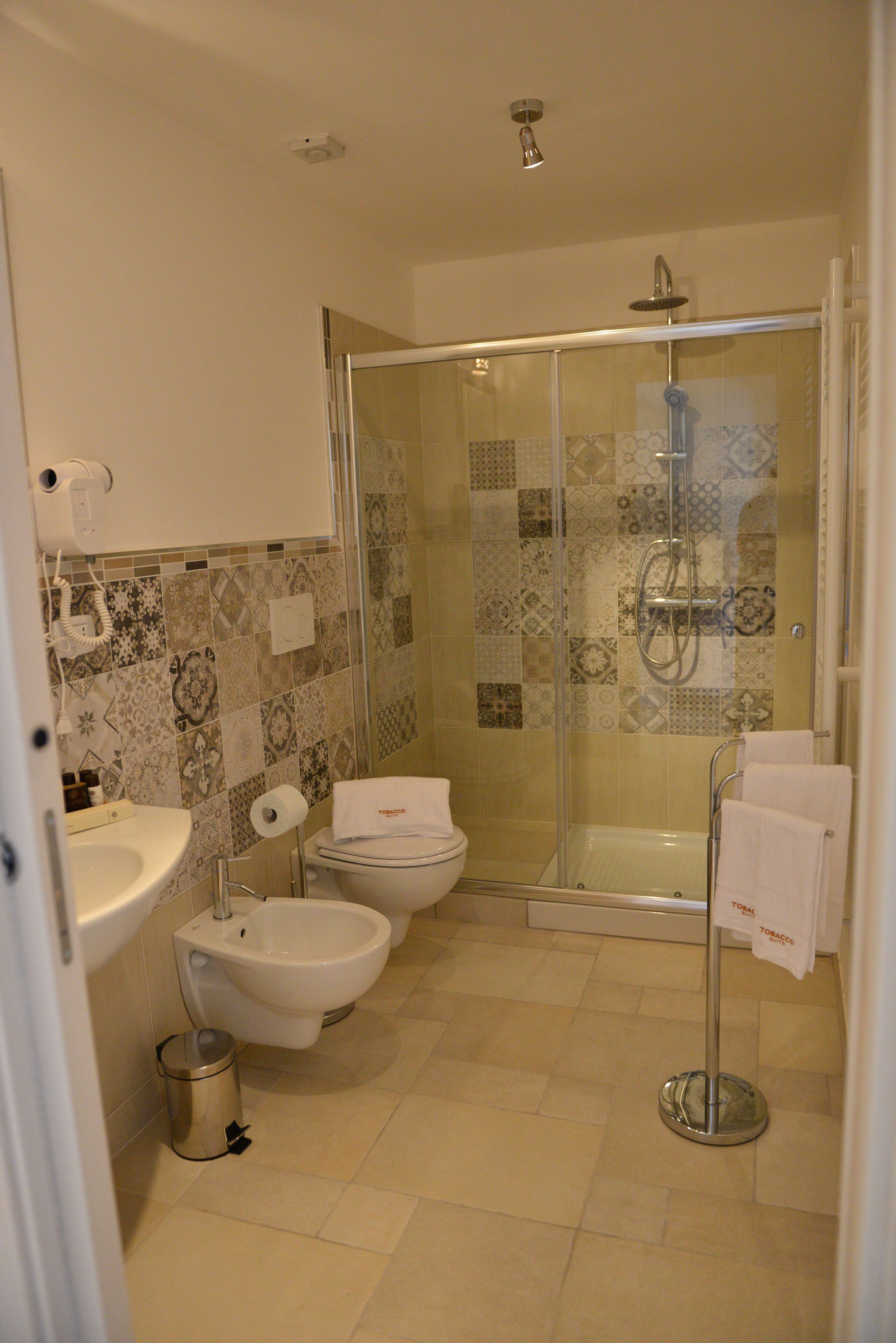 Une salle de bain moderne avec une douche à parois de verre, un bidet, des toilettes et un lavabo.