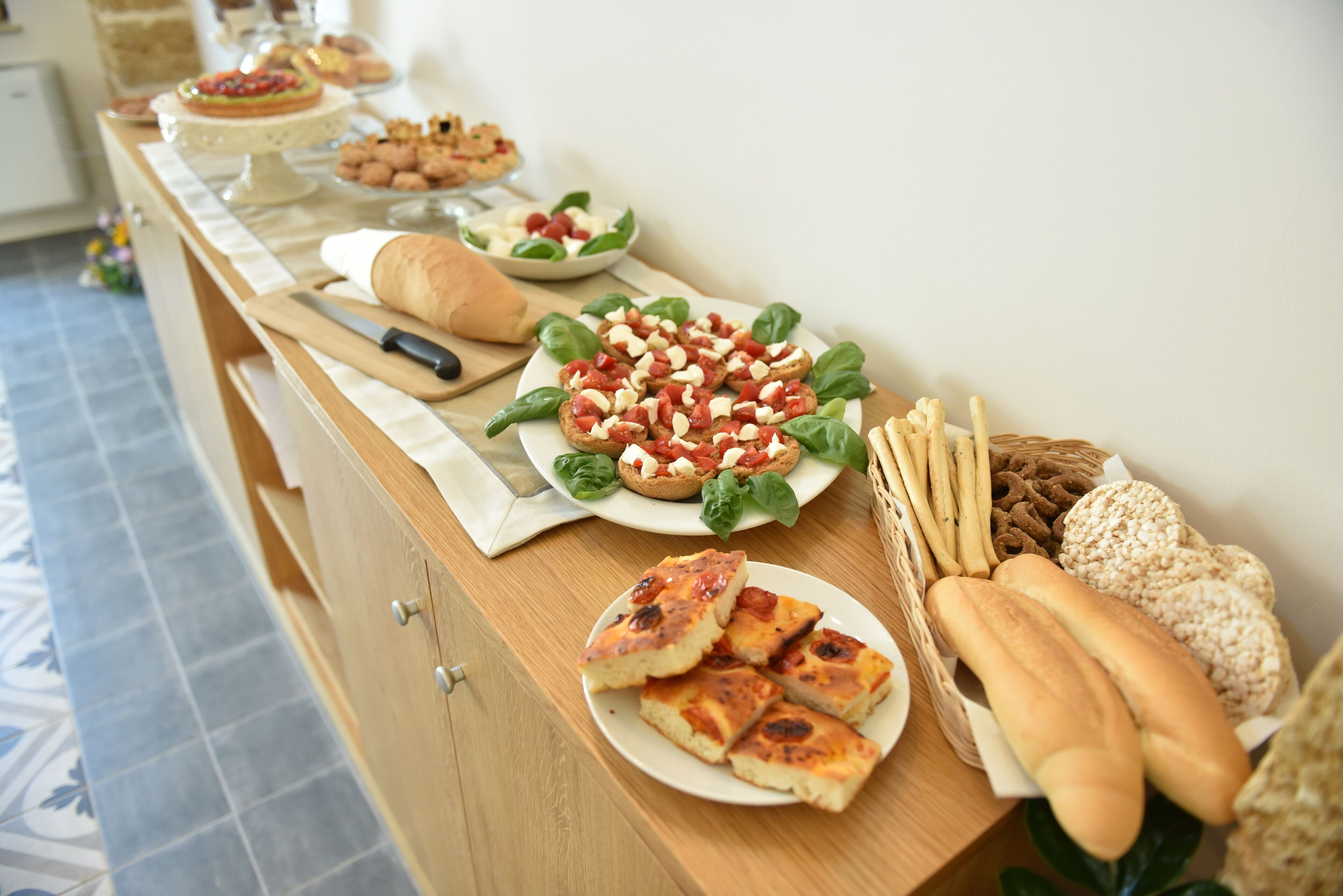 Una mesa de buffet con diversos alimentos, como pan, queso y ensaladas.